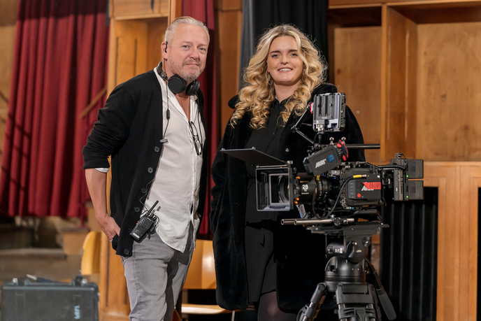 Filmmaker and Graduate stood with a camera