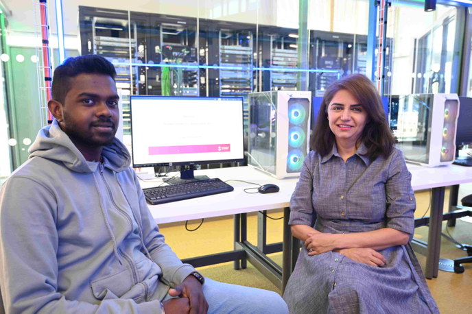 student and academic sat in front of a computer