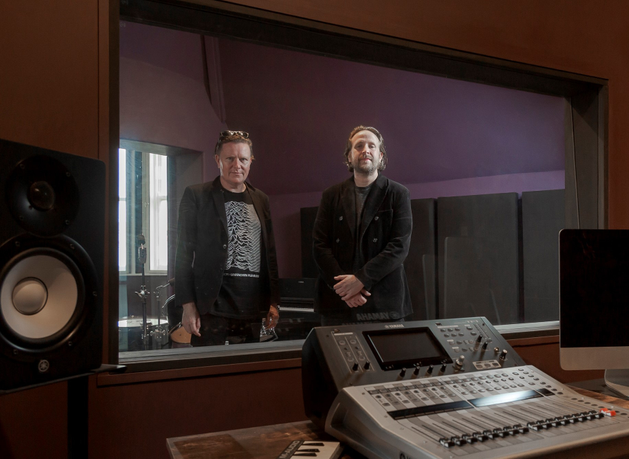 Two men standing in a music studio