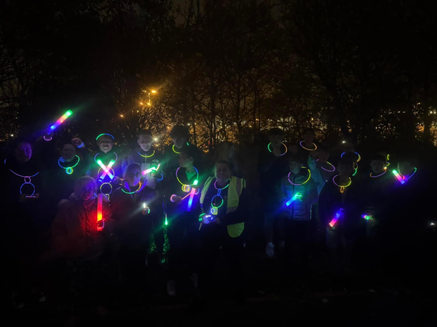 Young people walking at night with glow sticks