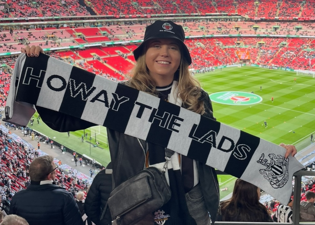 Chaplain stood in stadium with football scarf