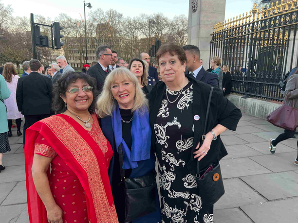 Academic stood with radio managers outside of Buckingham Palace