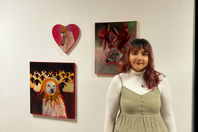 Student stood in front of her artwork