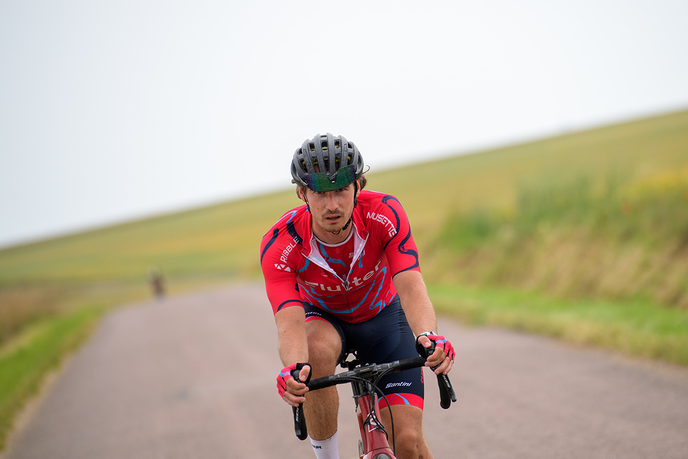 Graduate cycling down a hill