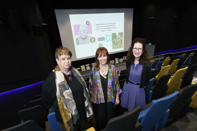 Academics and artist stood in cinema