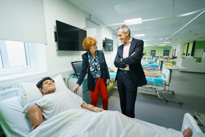 Two people standing in a mock hospital ward