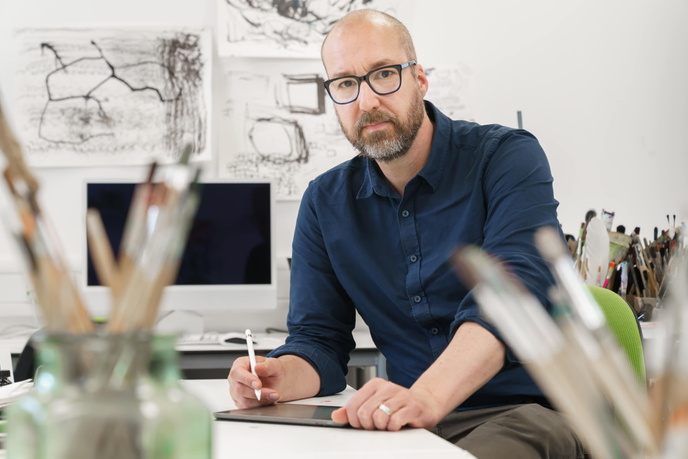 Man sitting at table drawing