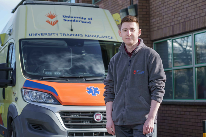 Student paramedic in front of Ambulance
