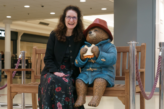 Academic sat with statue of Paddington bear