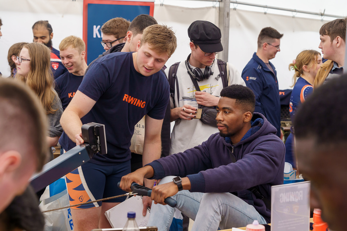 Student on rowing machine helped by another student