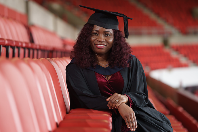 Graduate sat in stadium seats