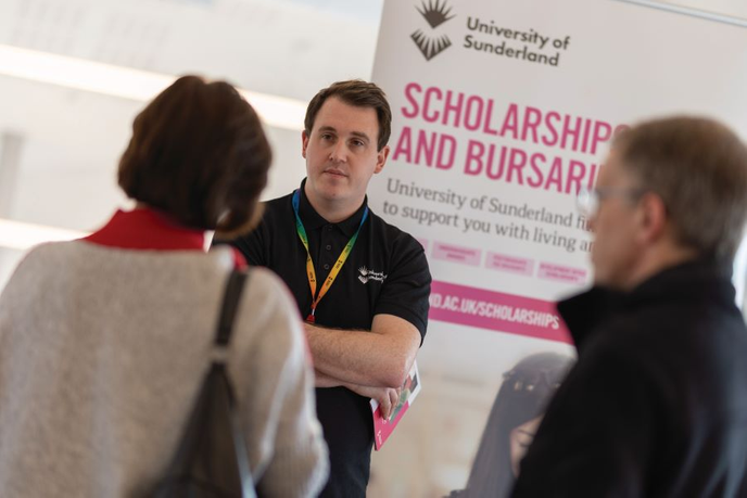 University staff member talking to students