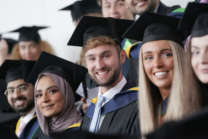 Graduates smiling at the camera