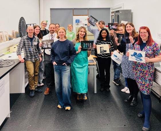 Group of people holding up photographs