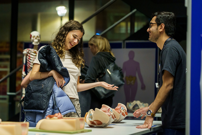 Attendee at event station looking at models