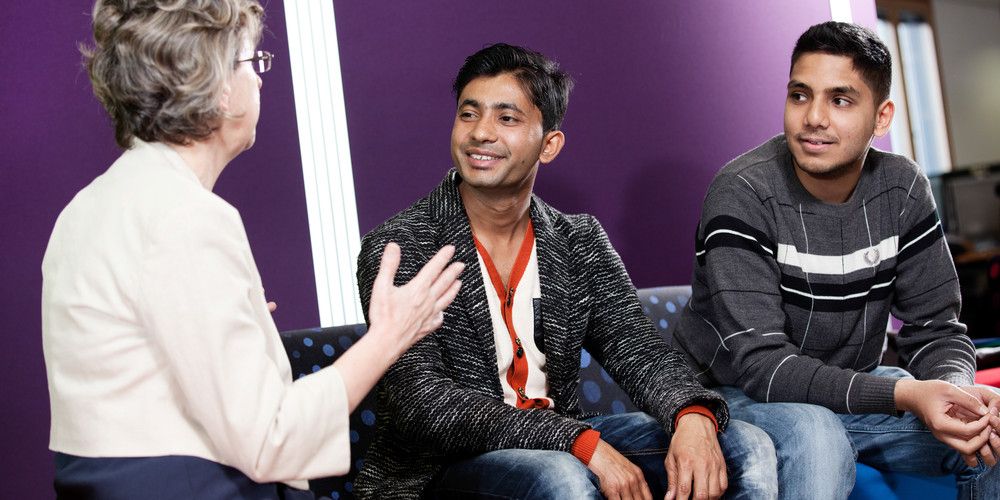 Two male students talking to a teacher