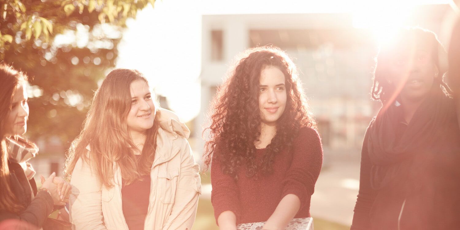 Two students smiling looking away from the camera