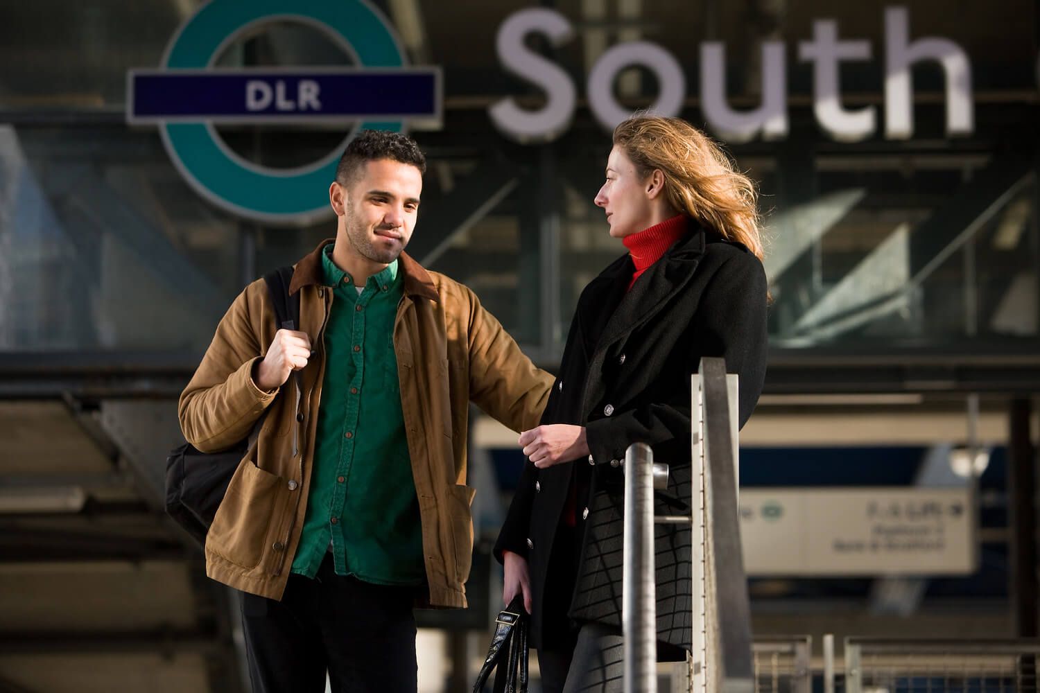 Two University of Sunderland in London students talking outside South Quay Docklands Light Railway train station