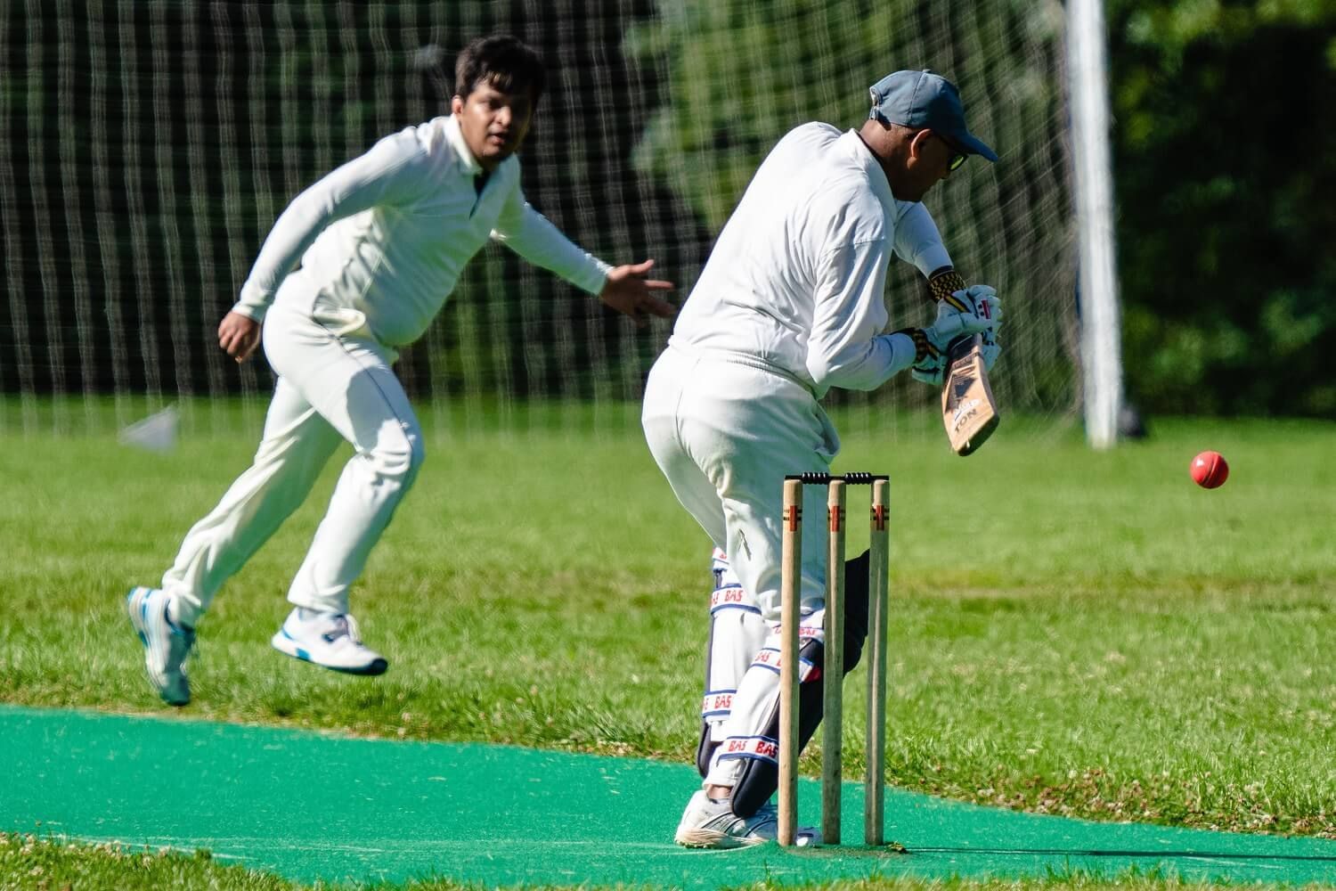 Two people playing cricket