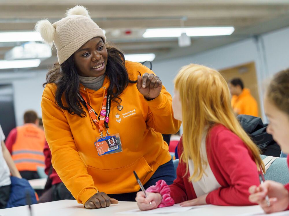 A student ambassador speaking to a school pupil during an outreach session