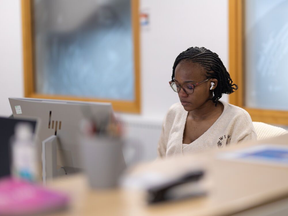 A person working on a desktop computer in an office