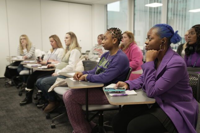 A group of women listening to a talk in a classroom on International Women's Day