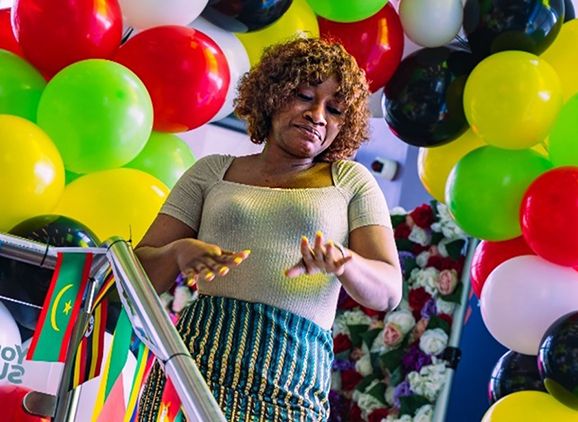 A student dancing surrounded by balloons.