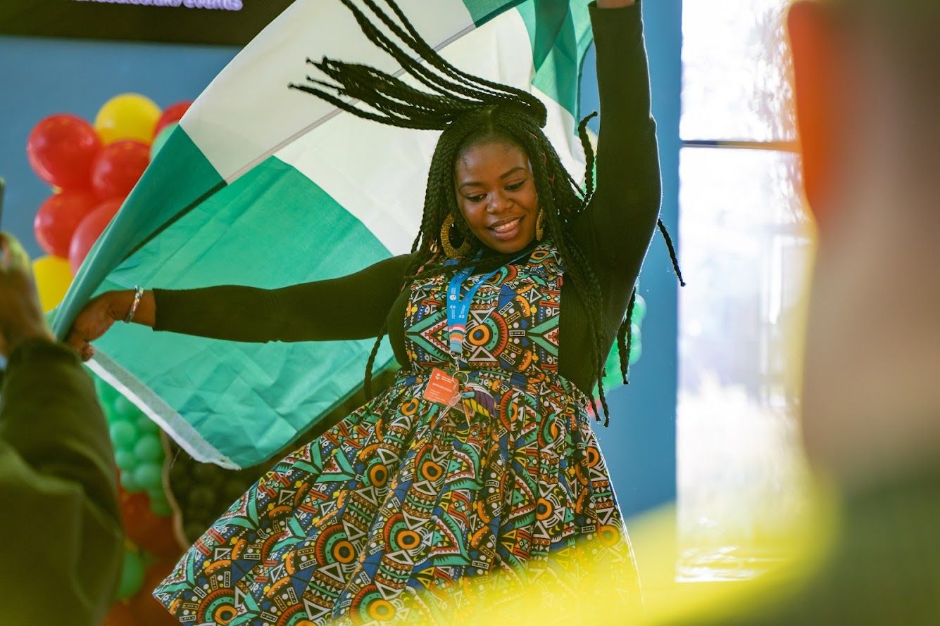 A student dancing with a Nigerian flag