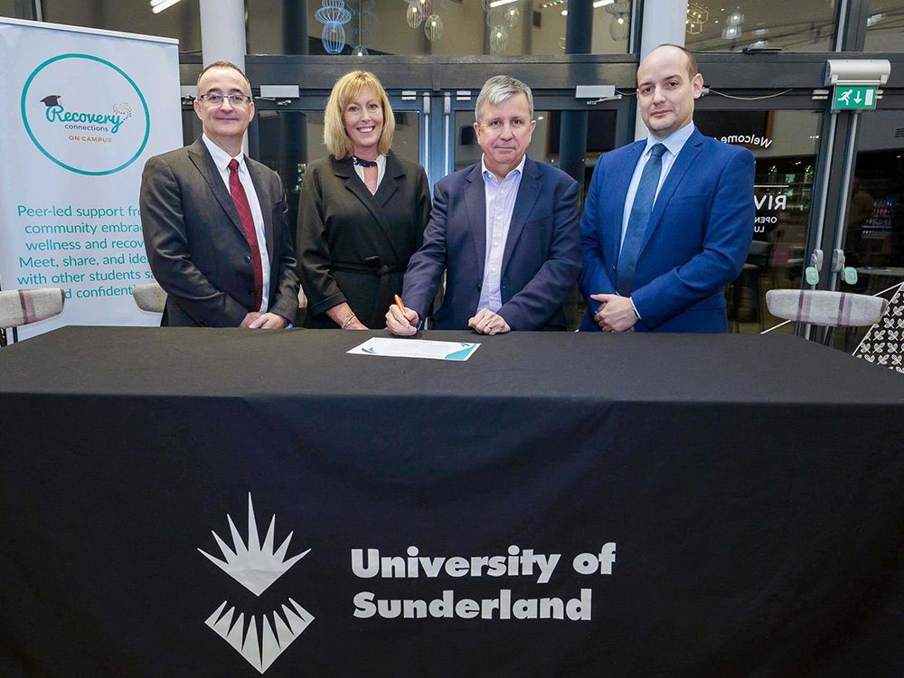 Four people standing at a University of Sunderland stall with the recovery pledge