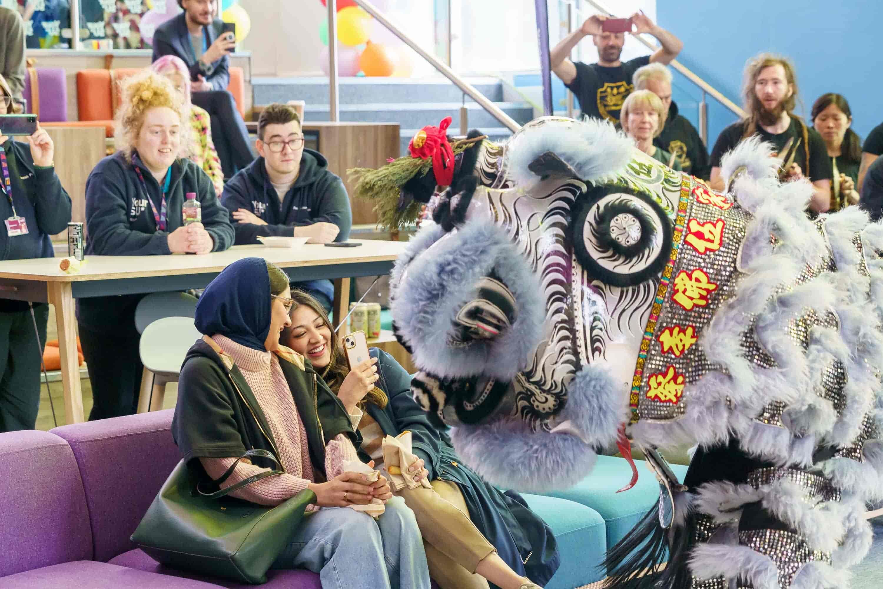 Two students interacting with a Chinese dragon at the Global Food Festival