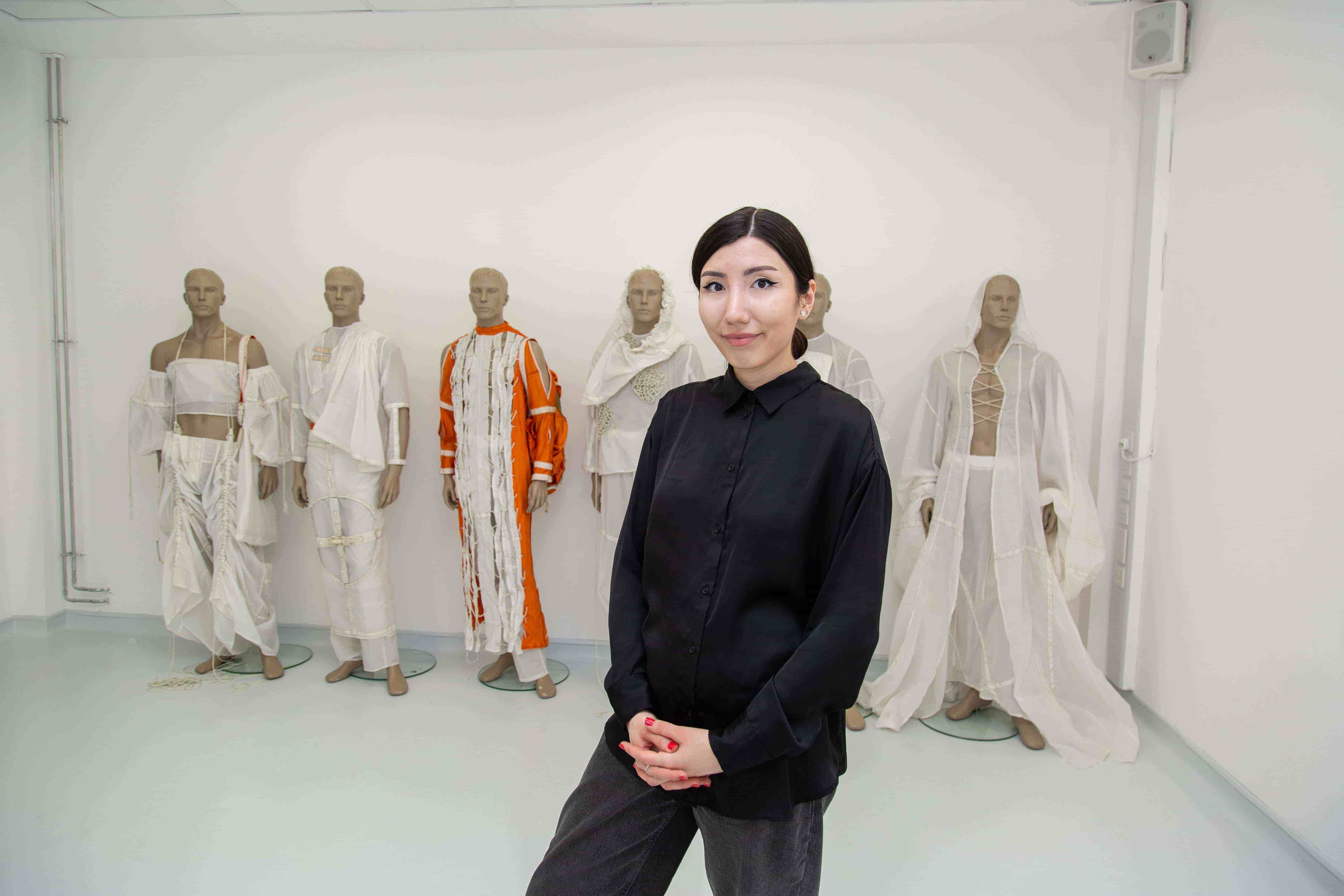 Hulya Anefi standing in front of the clothing she designed.