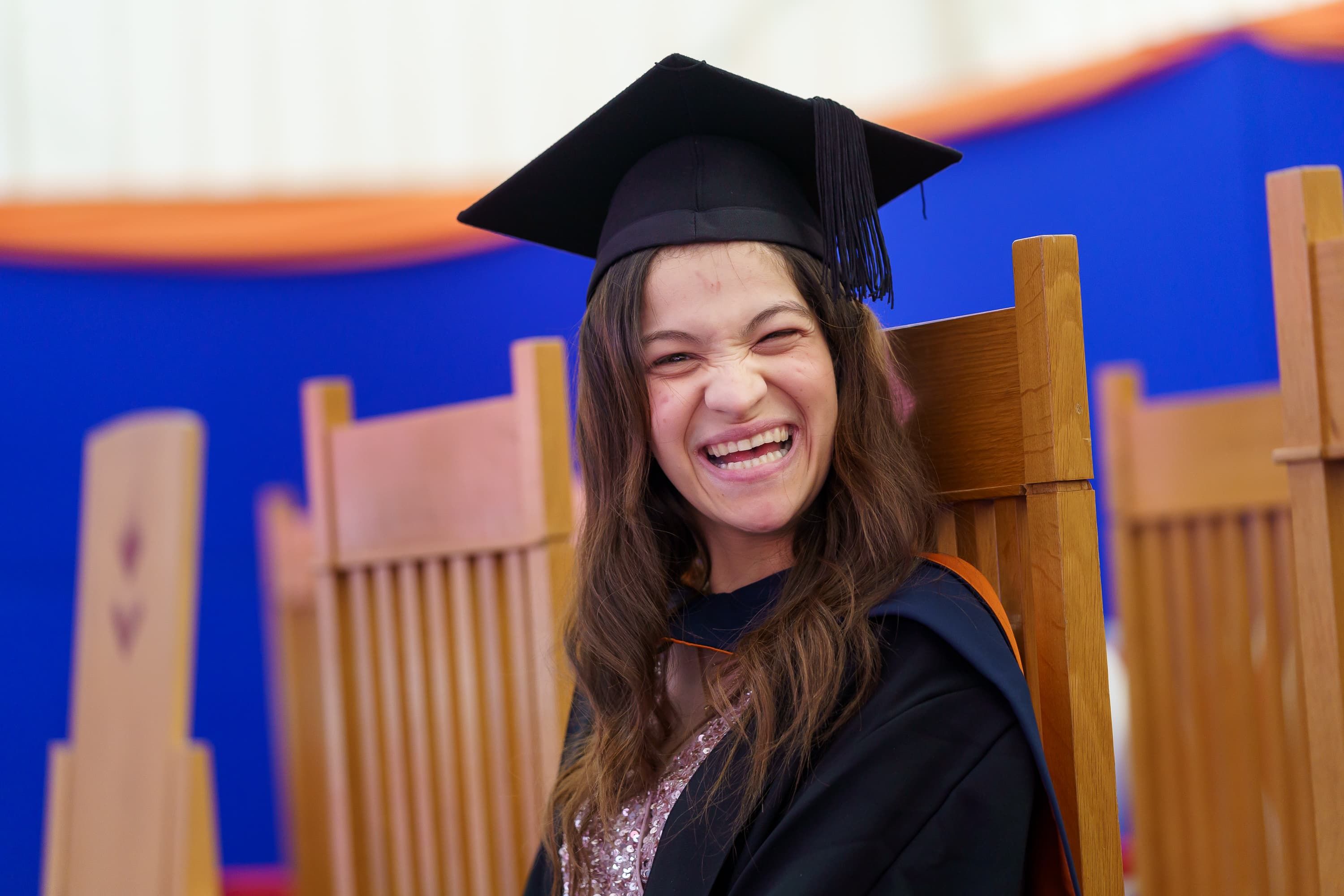 Kamelia smiling in her graduation gown and hat