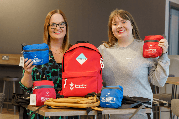 Two colleagues holding up Madlug bags