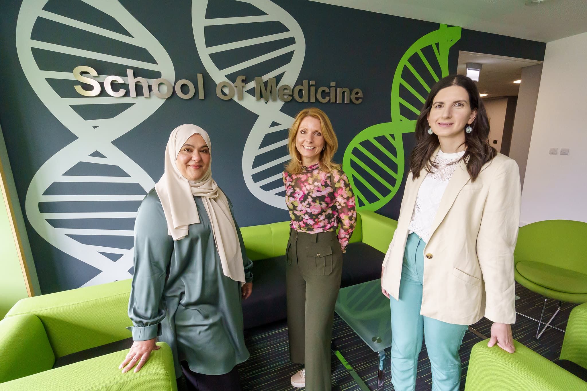 Dr Floor Christie-de Jong, Dr Rawand Jarrar, and Cerysh Sadiq standing in front of the School of Medicine smiling to camera