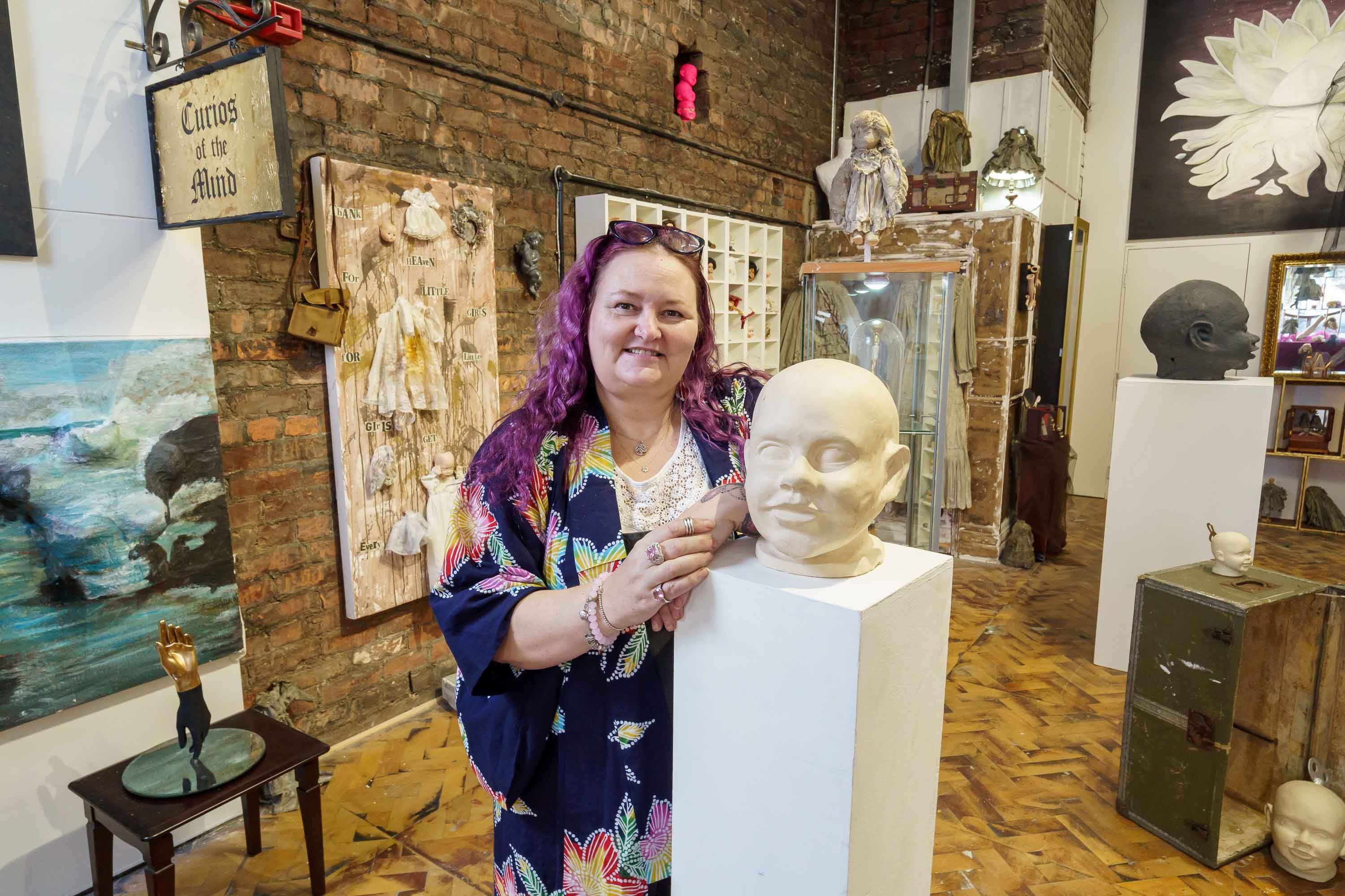 Student smiling next to art work statue