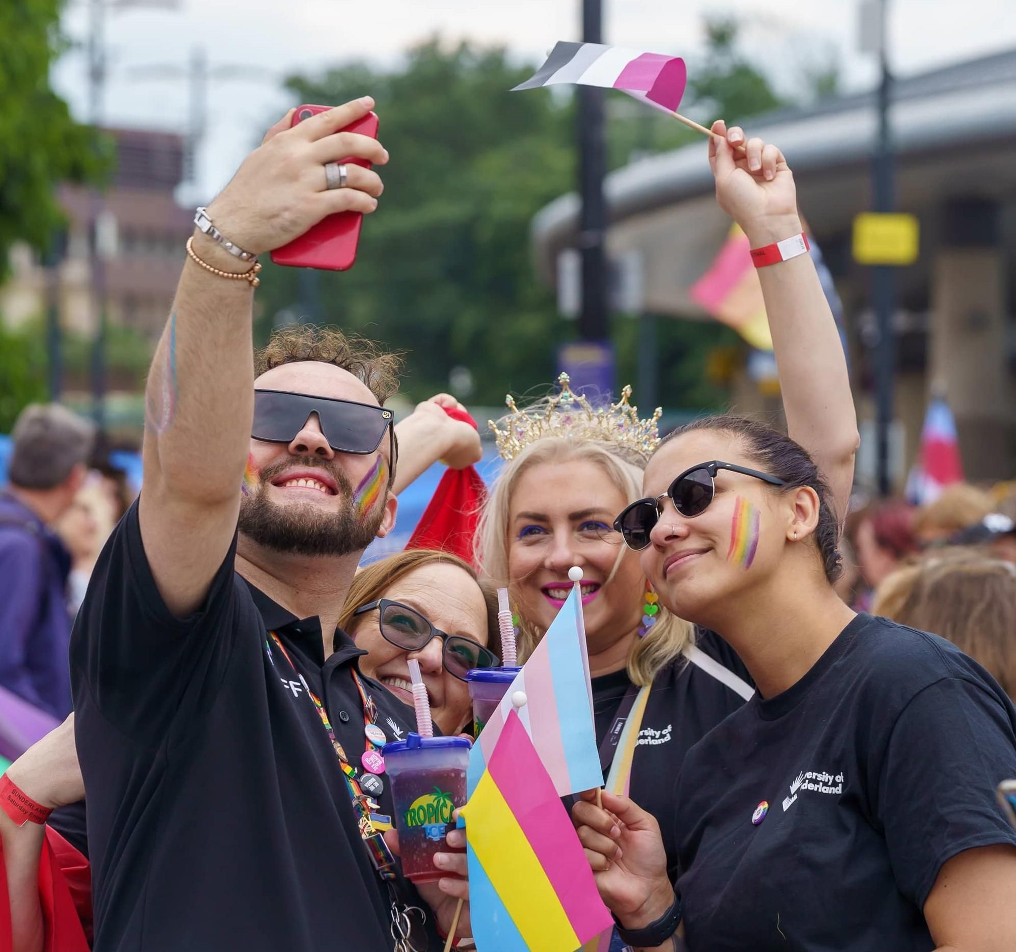 Four people at Sunderland Pride wearing rainbow accessories taking a selfie