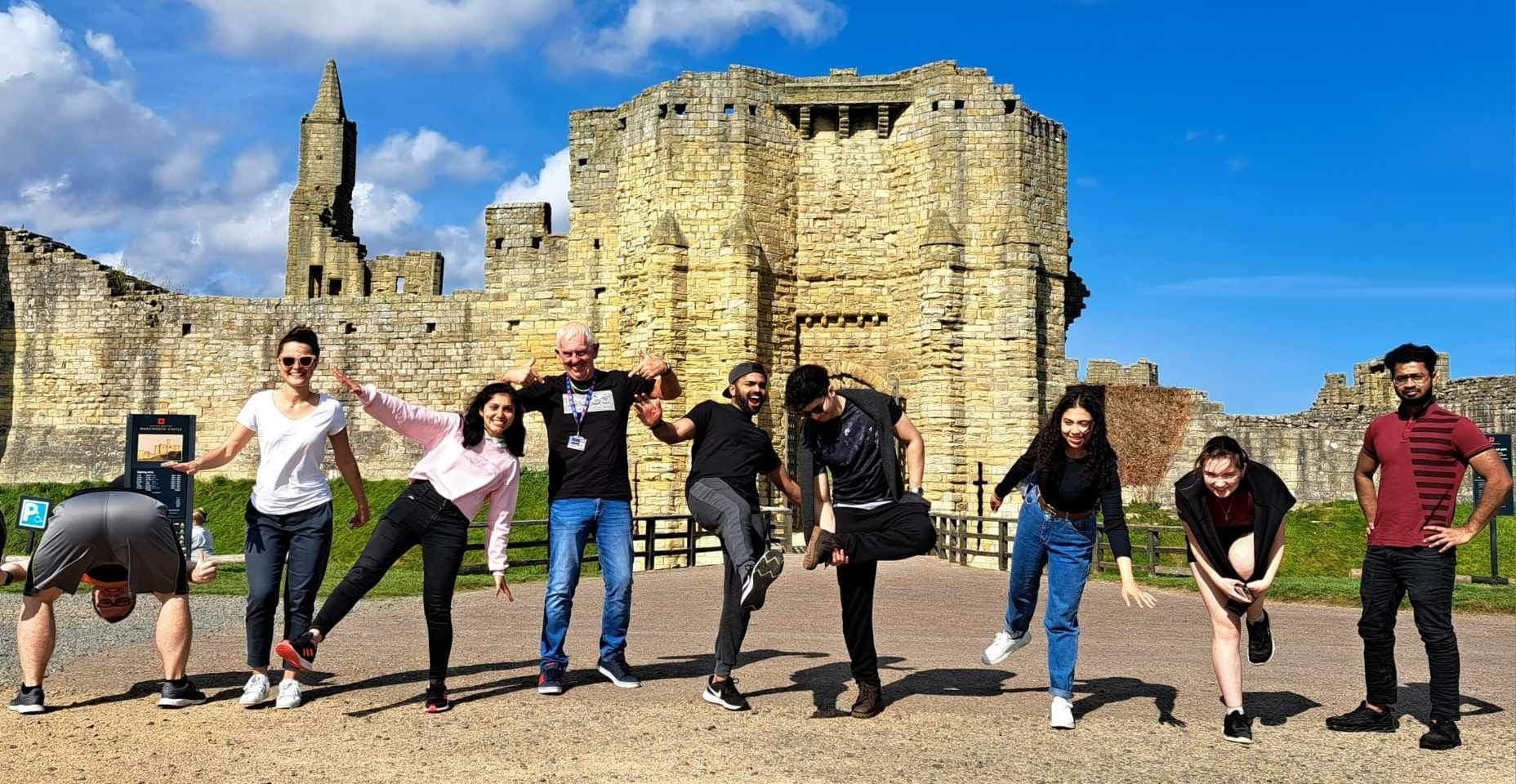 Student posing in front of a castle in the sunshine