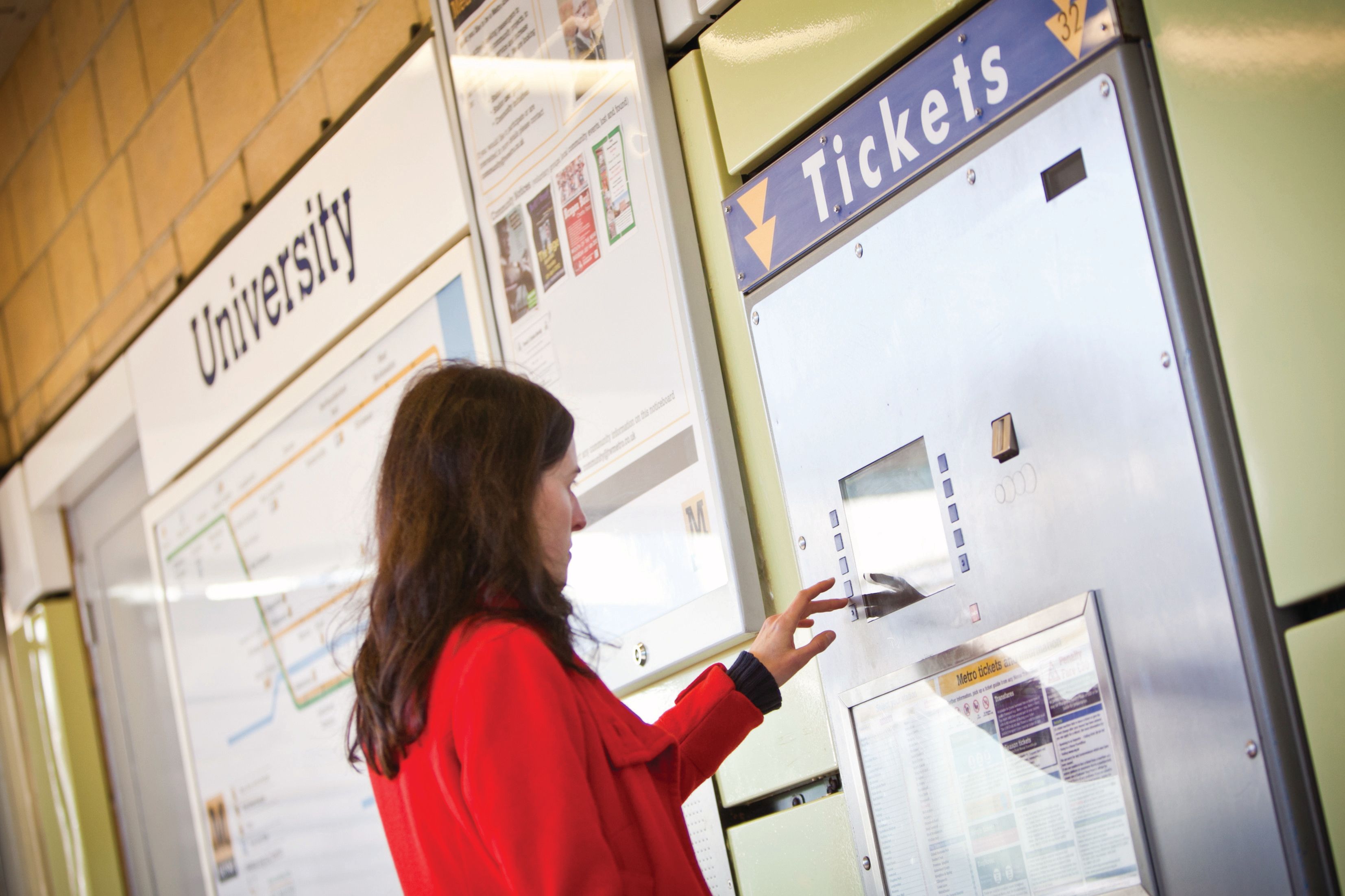A woman purchases a metro ticket at University station