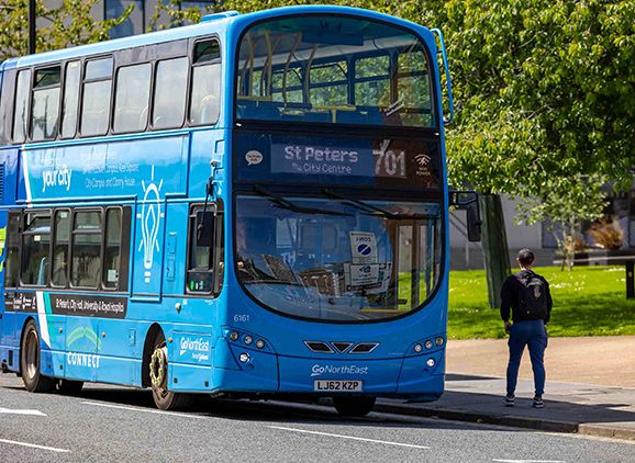 The blue campus double decker bus pulled up at City Campus with a student about to get on