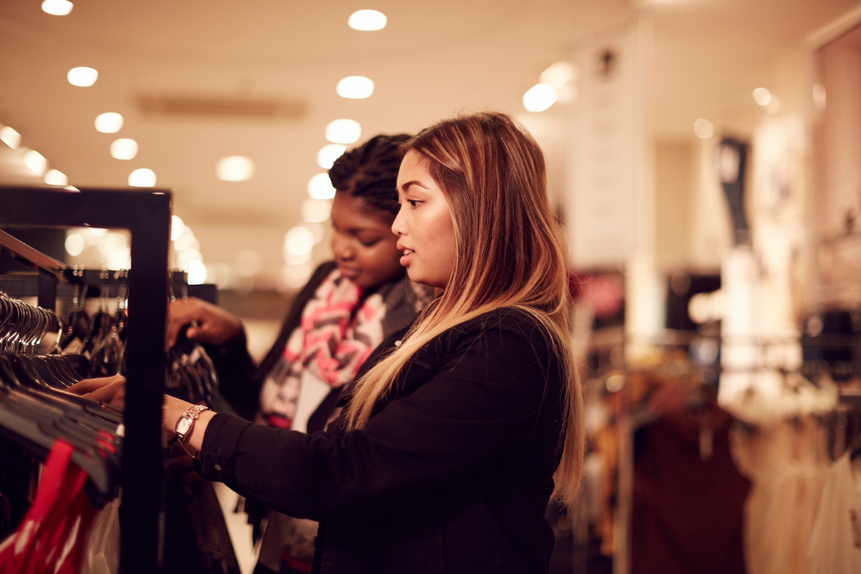 Two students looking through a clothes rail in a shop