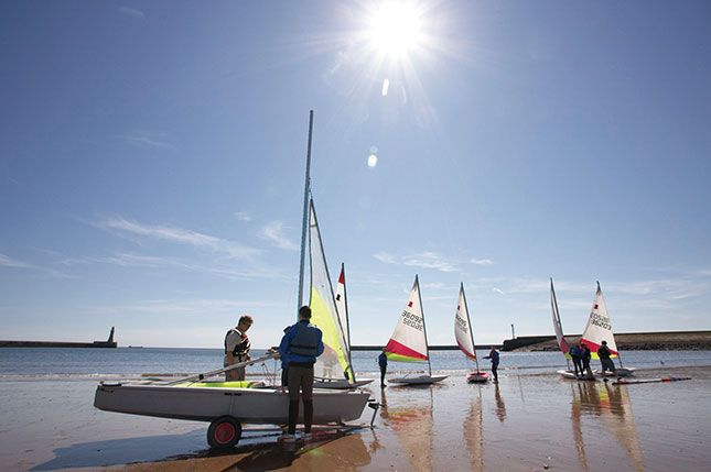 Sailboats sitting on a beach in Sunderland on a sunny day