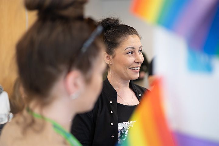A student smiling surrounded by pride colours