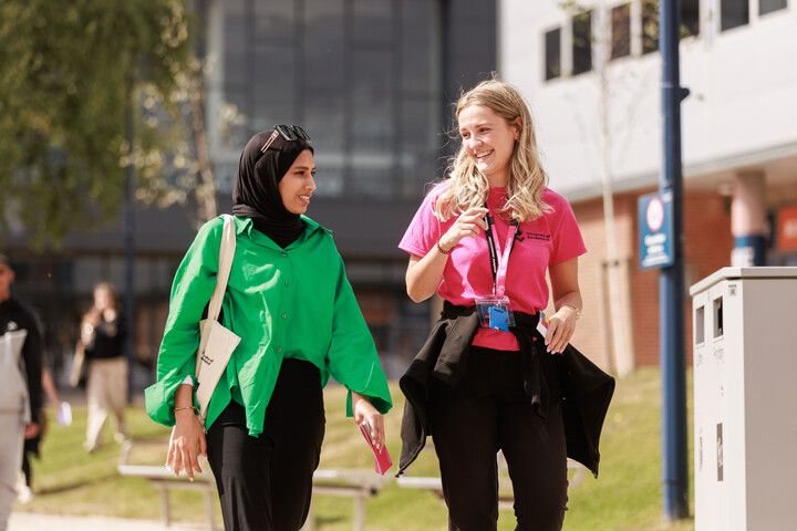 A student ambassador guiding a guest around the campus