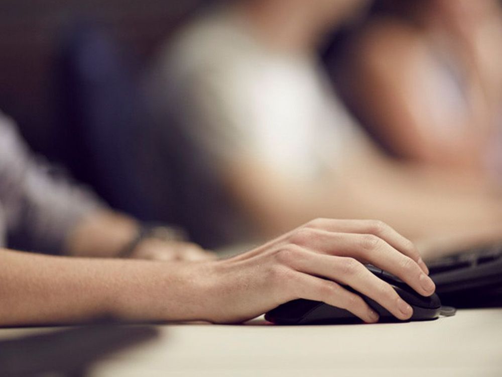 A hand moving a computer mouse