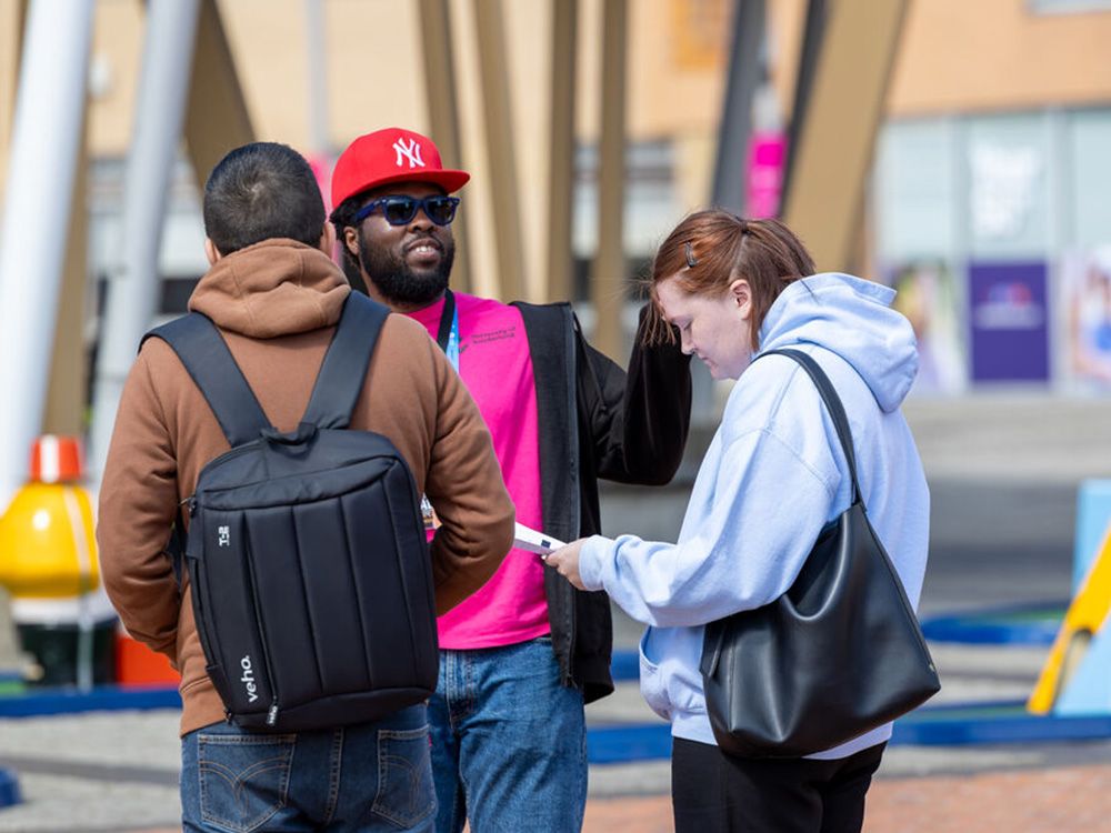 A Student Ambassador talking to two people on campus