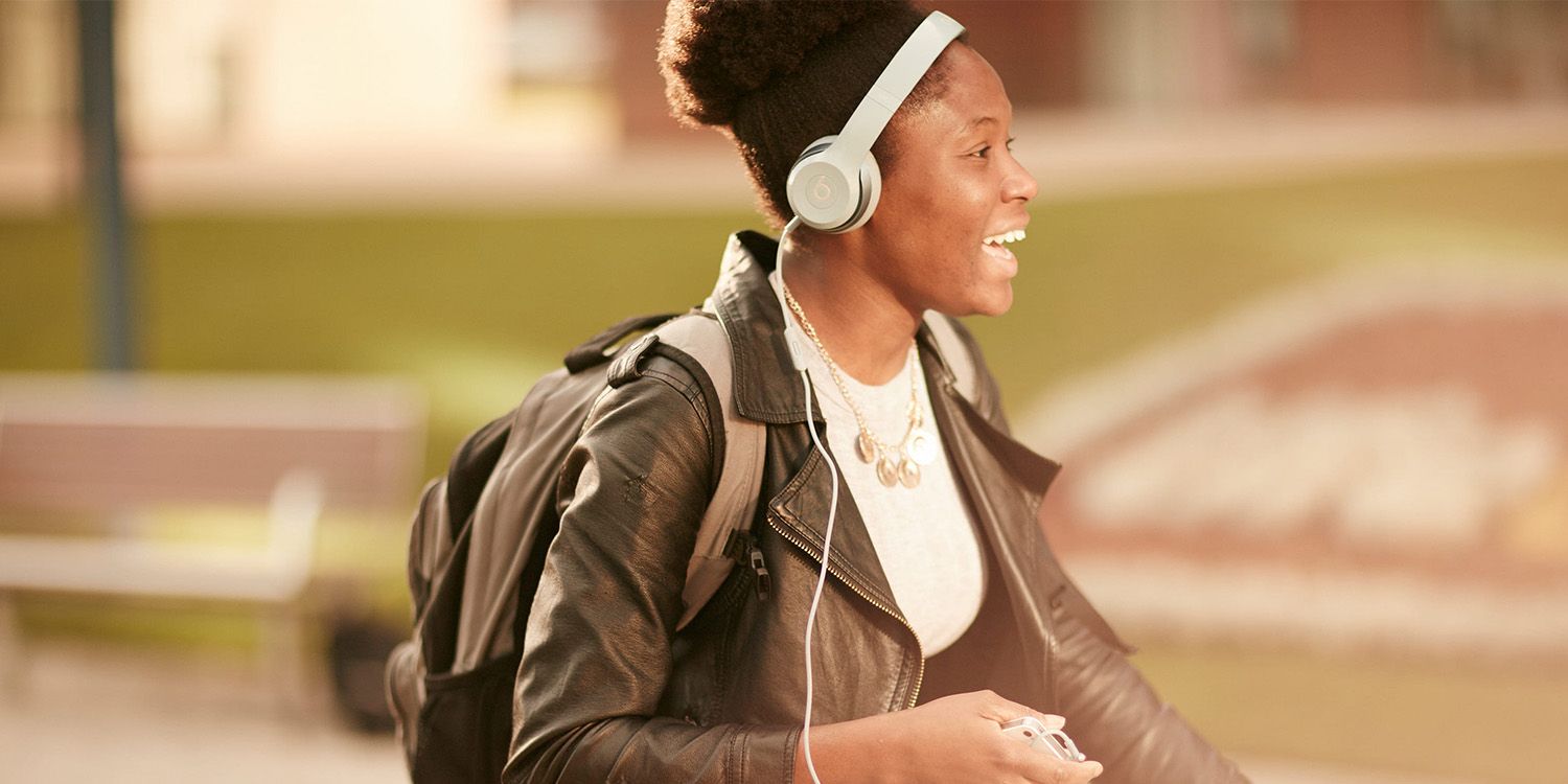 A student listening to music walking around campus