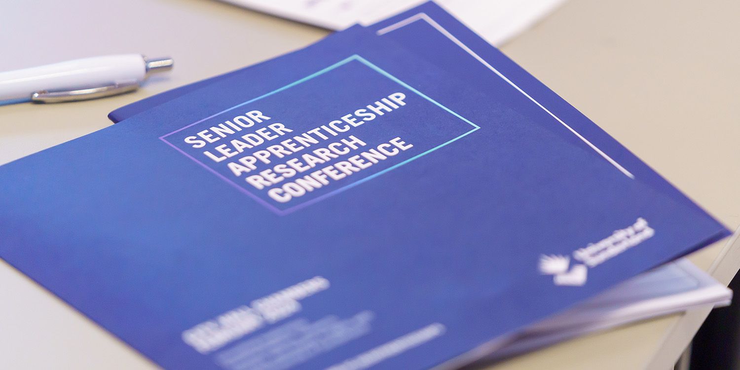 A blue leaflet with Senior Leader Apprenticeship Research Conference written on it