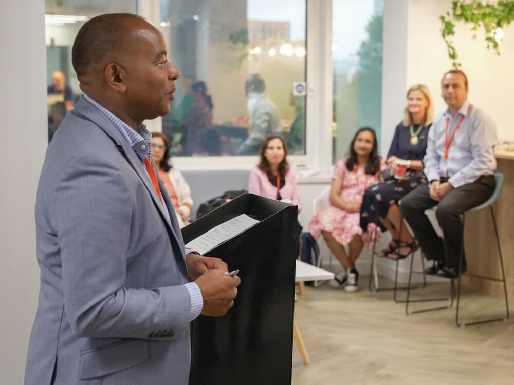 A teacher talking at the front of a room of people