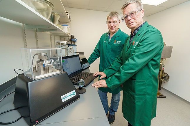 Dr Michael Gamlen with Dr Adrian Moore next to a Gamlen tablet press machine