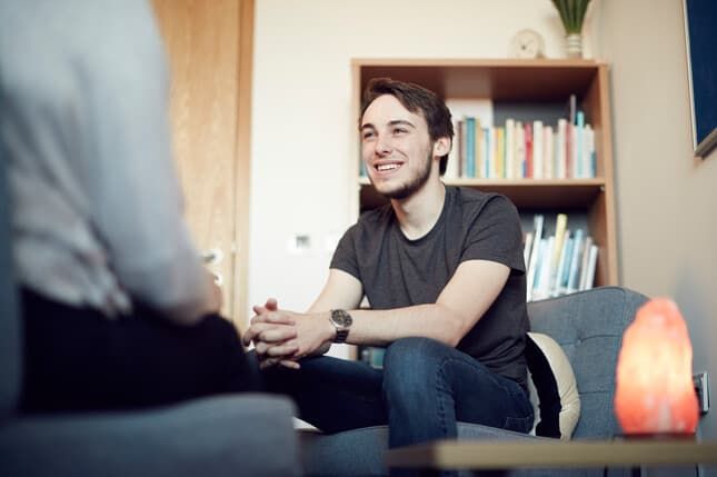 A student chatting with a mentor and smiling